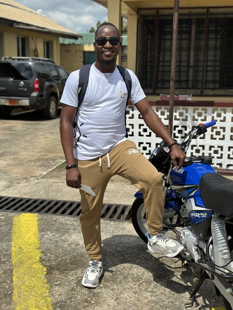 Emmanuel leaning on a motorcycle casually
