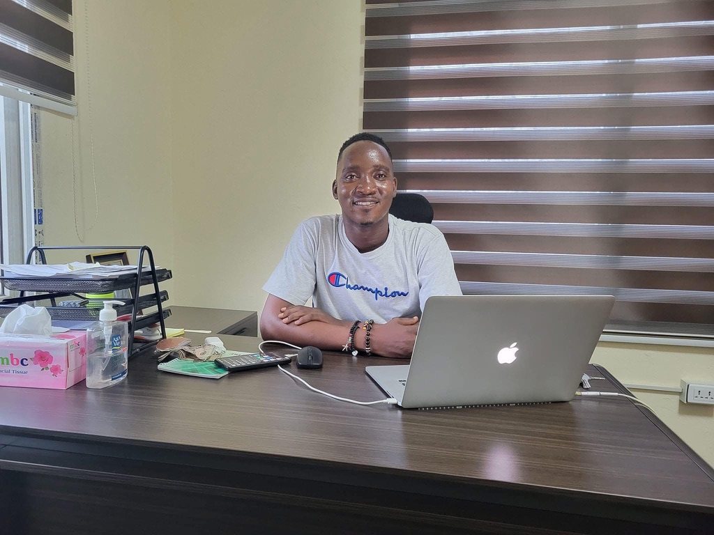 Emmanuel working at an office desk